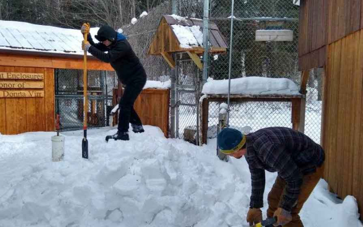 two people use snow tools during a service project with outward bound